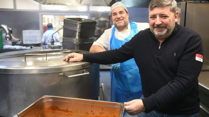 Óscar Castro, con un compañero, posa, ayer, con las albóndigas que había en el menú. | C. Pardellas