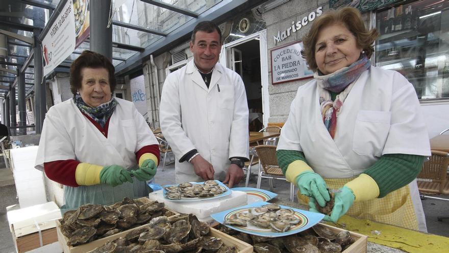 Isabel Seoane (dcha), en el mercado de la Piedra de Vigo, con su hermana María y un ostrero.