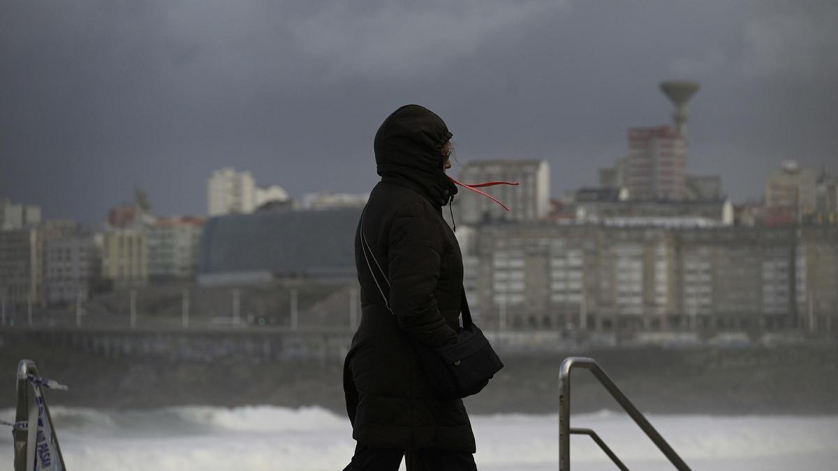 Una persona pasea por Riazor durante una jornada con temporal costero.