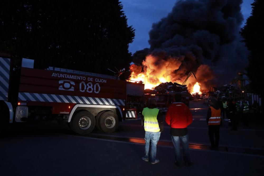 Labores de extinción del incendio de un desguace en Gijón