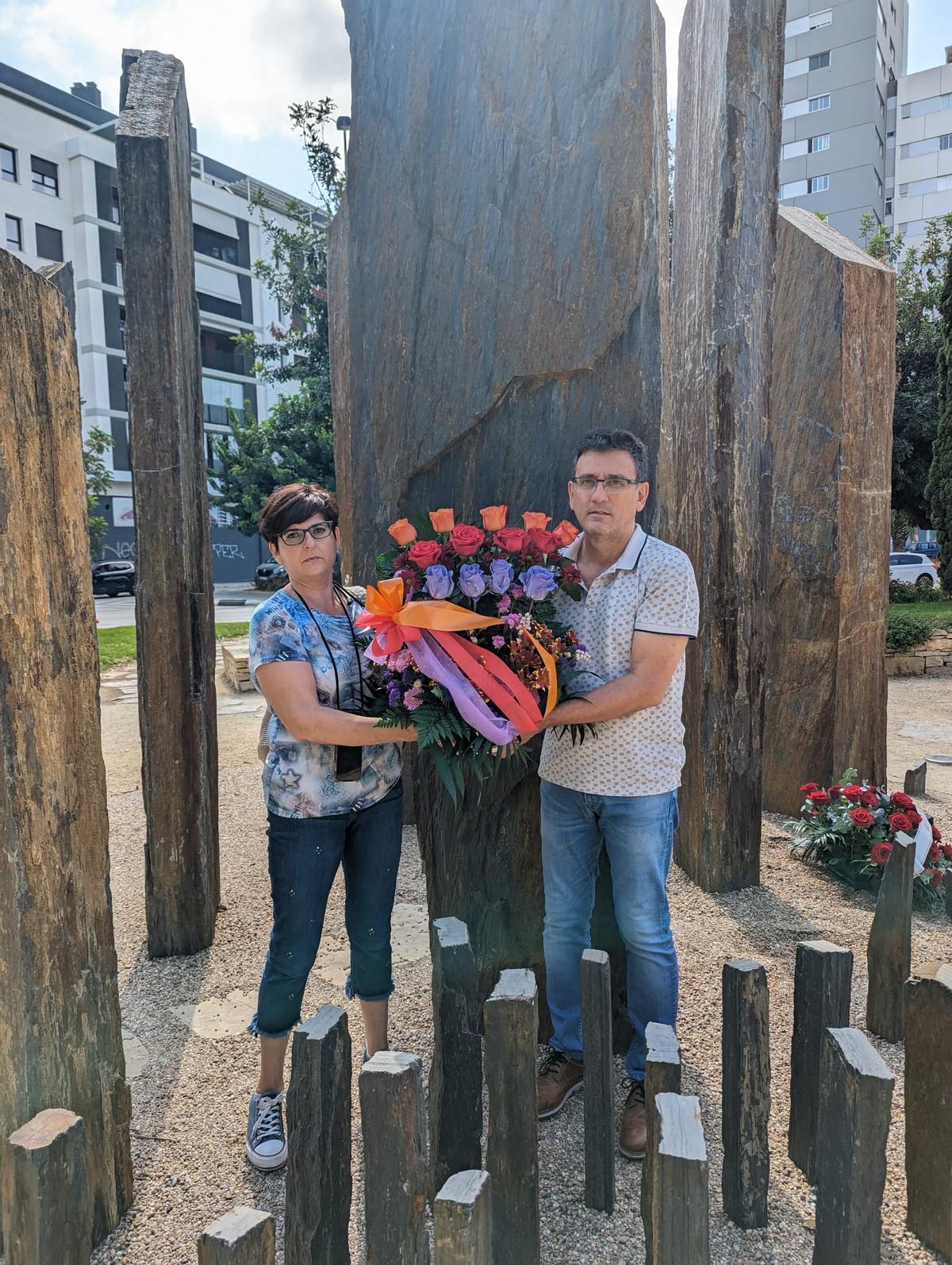 Los dos ediles de Compromís colocan las flores.