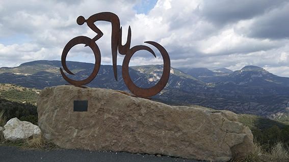 Estàtua. Monument al ciclista, en agraïment al Tour de França 2009; al fons, la nuvolada que tapa les muntanyes del Montnou i el port del Comte.