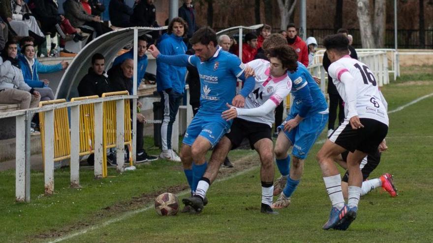 Un jugador azulón protege el cuero de un adversario. | Emilio Fraile