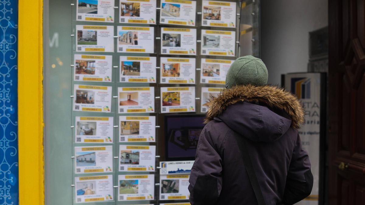 Una persona mira anuncios en el escaparate de una inmobiliaria en la ciudad de Zamora.