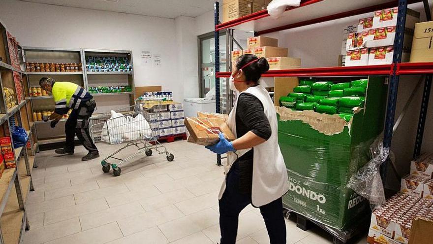 Una voluntaria prepara un lote de comida para los usuarios del Banco de Alimentos de Cáritas.