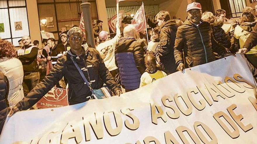 Janette Mancabu e Izidro Monteiro Camala, con su hija Janette Elena, despliegan la pancarta con la que el colectivo de africanos en Asturias se sumó a la manifestación en apoyo de la plantilla de Alcoa.