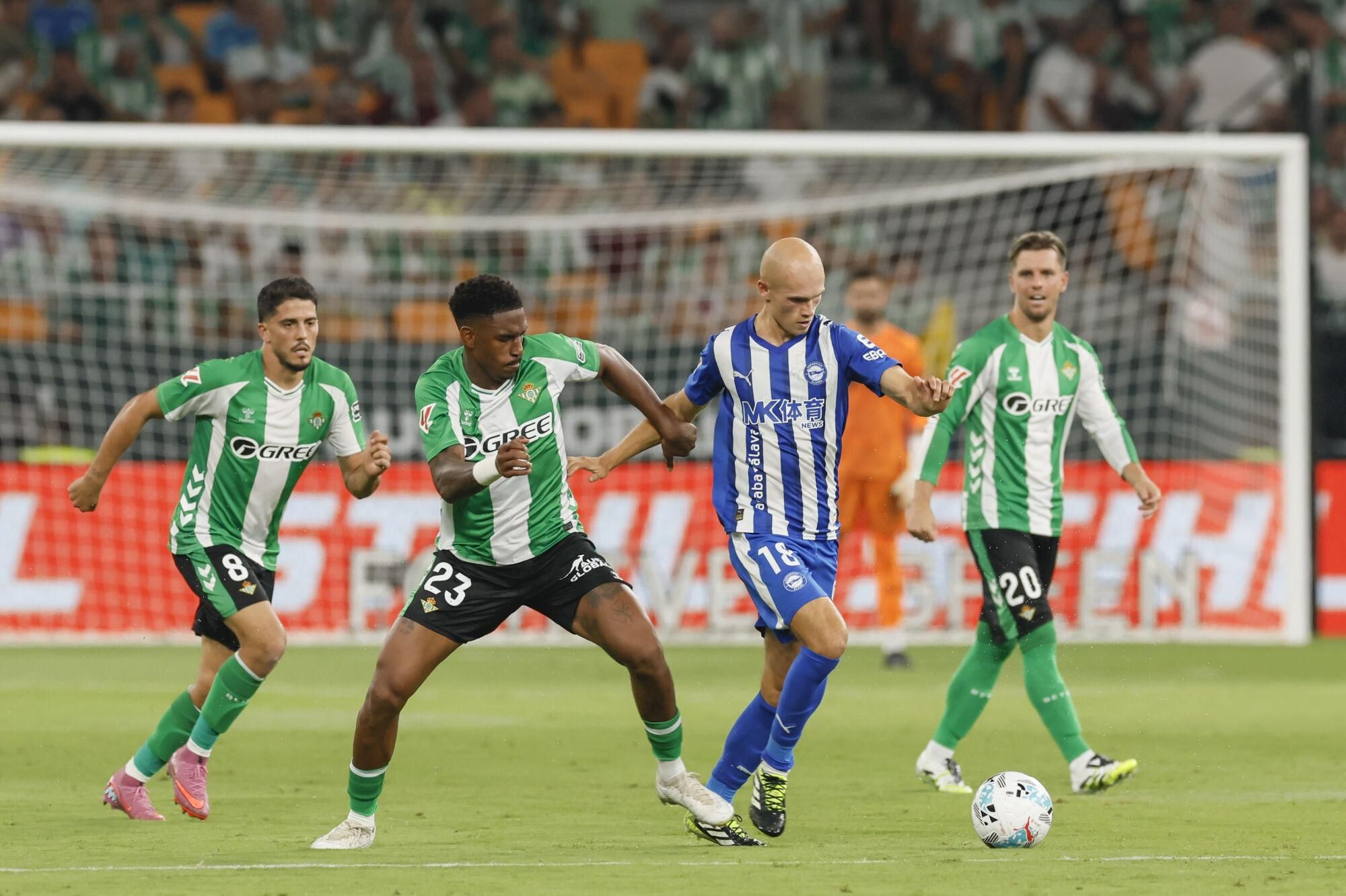 SEVILLA, 22/08/2025.- El lateral del Betis Junior Firpo (2i) ante el centrocampista del Alavés Jon Guridi (2d) durante el partido de LaLiga EA Sports entre el Real Betis y el Alavés, este viernes en el estadio de la Cartuja. EFE/ José Manuel Vidal