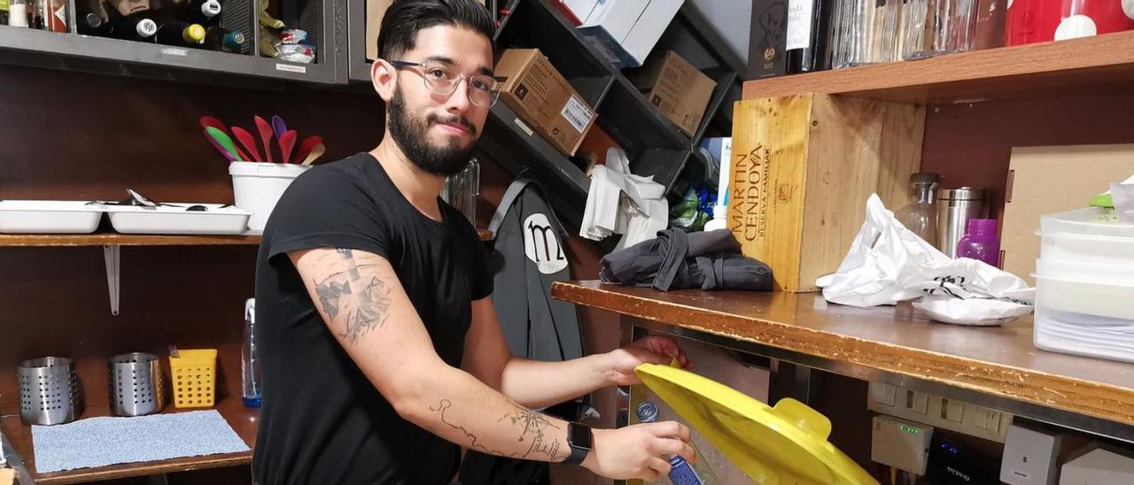 Un trabajador del restaurante Martinnus, en Cangas, muestra el contenedor amarillo.   | // SANTOS ÁLVAREZ