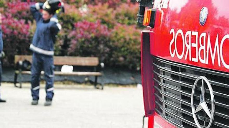 Dos efectivos del cuerpo de Bomberos de Gijón, en el parque de Roces.