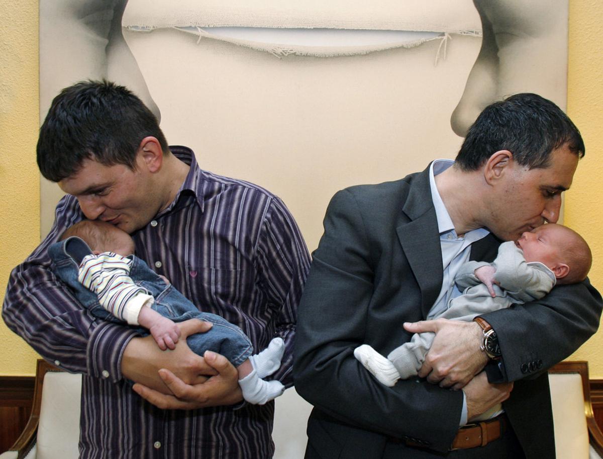 Dos padres acunan a sus bebés.