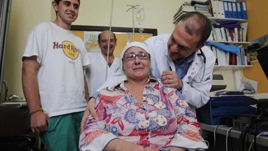 revisión y regreso a ceceda.  Graciela Cocina Ovín, emocionada, durante su comparecencia de ayer en el Hospital Central de Asturias (HUCA), junto a su hijo menor, José Ramón. Les acompañan el doctor Carlos Vallejo y, al fondo, José Antonio Carvajal, supervisor de enfermería de la unidad de trasplantes.