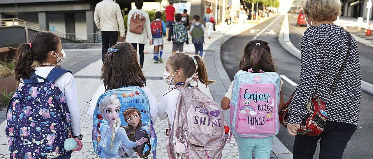 Niñas acudiendo al colegio con mascarilla.