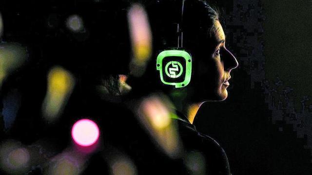 Una mujer con unos auriculares en una instalación de un festival.