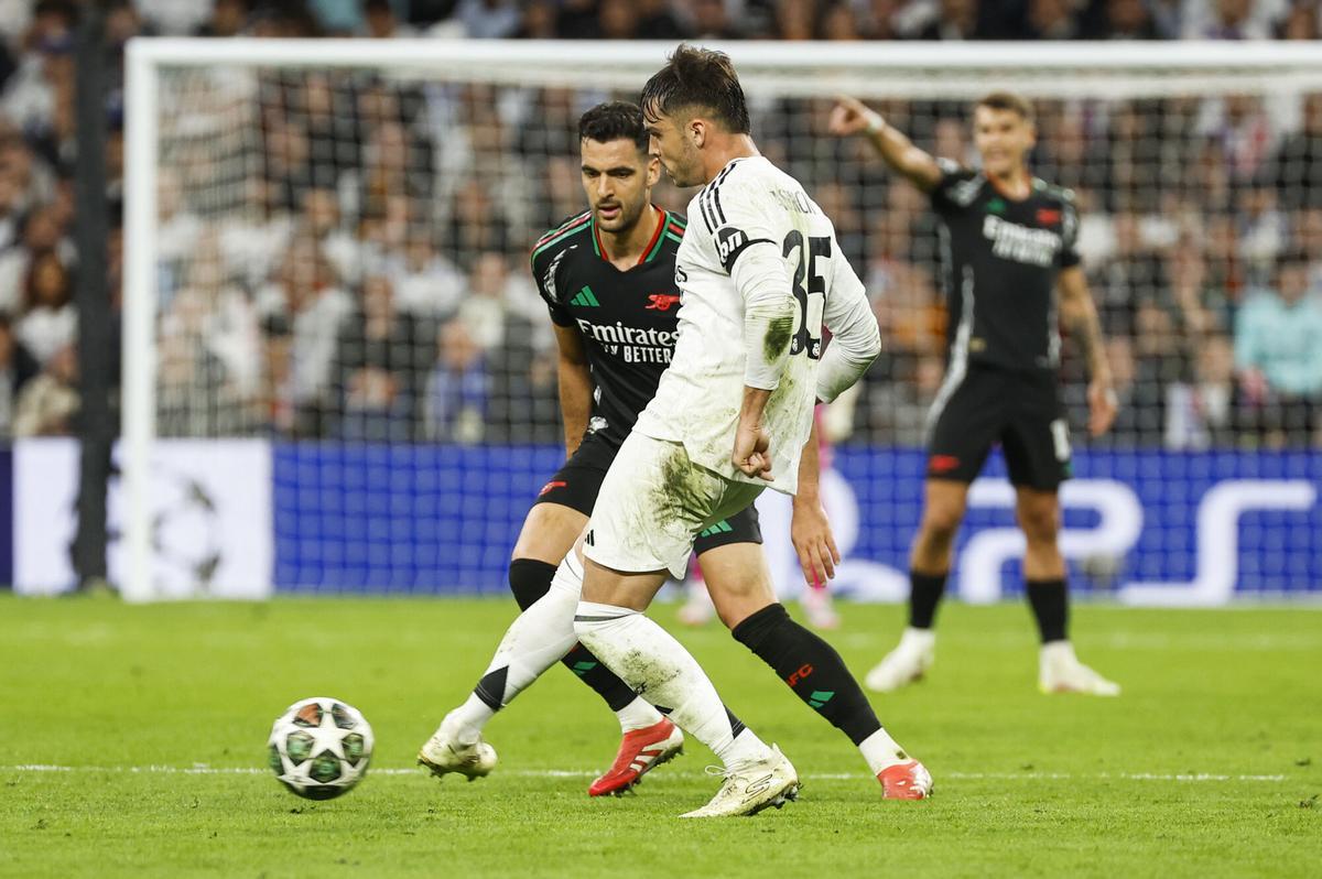 MADRID, 16/04/2025.- El defensa del Real Madrid, Raul Asencio, golpea el balón ante el centrocampista español del Arsenal, Mikel Merino, durante el encuentro de vuelta de cuartos de final de la Liga de Campeones que Real Madrid y Arsenal juegan hoy miércoles en el estadio Santiago Bernabéu. EFE/Mariscal.