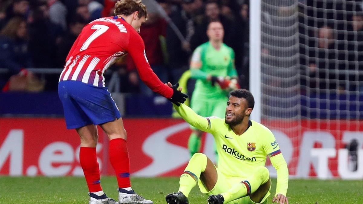 Griezmann ayuda a Rafinha a levantarse en la segunda parte del Atlético-Barça en el Metropolitano.