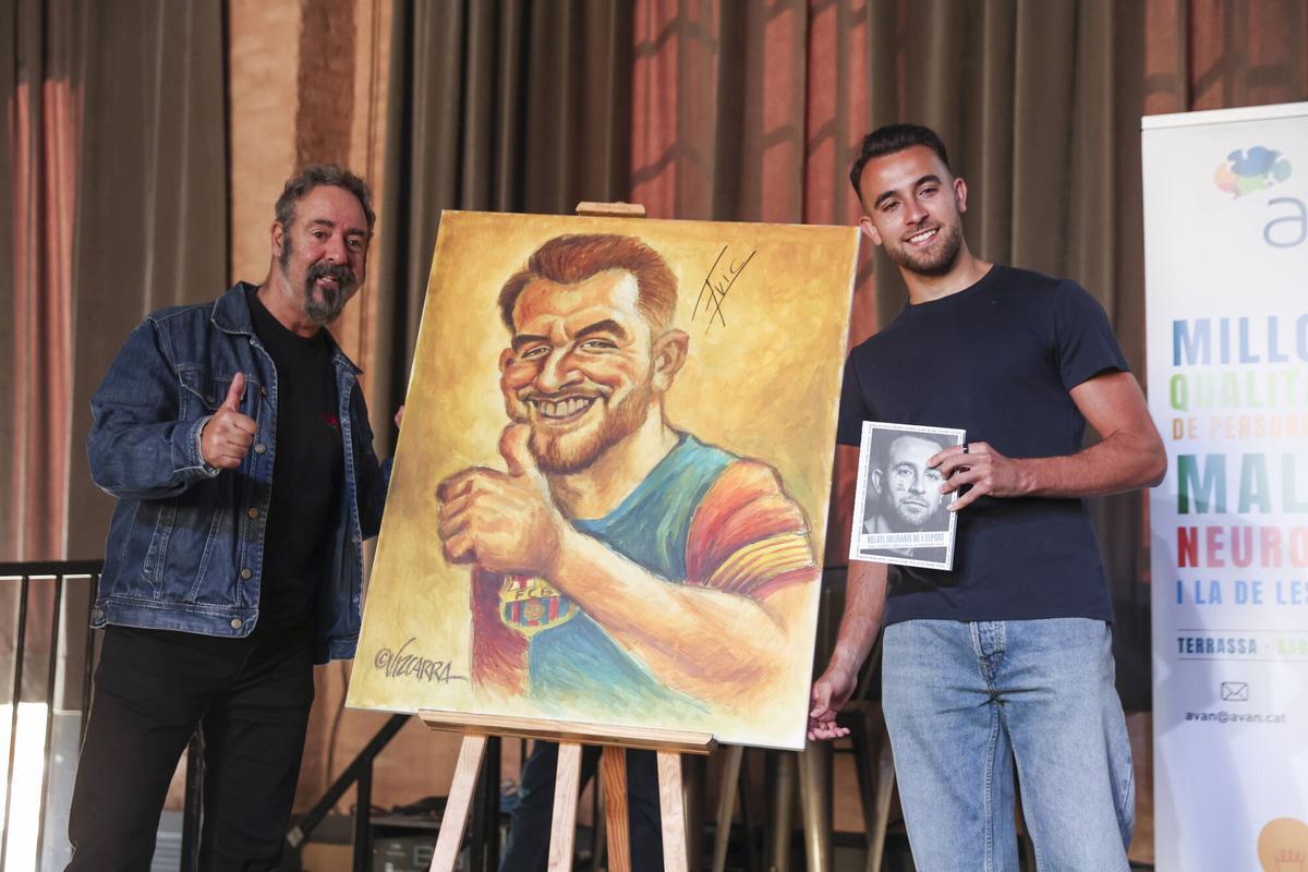 Eric posa con Joan Vizcarra, el ilustrador que ha ha pintado un cuadro con su caricatura que será subastado.
