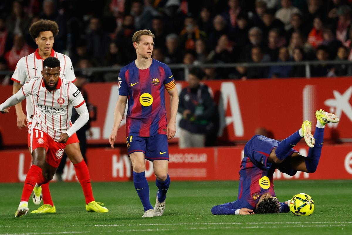 Barcelona's Lamine Yamal falls next to Barcelona's Frenkie de Jong and Girona's Thomas Lemar during a Spanish La Liga soccer match between Girona and Barcelona in Girona, Spain, Monday, Feb. 16, 2026. (AP Photo/Joan Monfort)