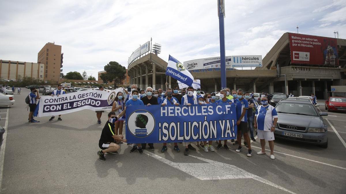 Integrantes de Asociación Herculanos portan una de sus pancartas antes de una acción de protesta contra la gestión del club alicantino.