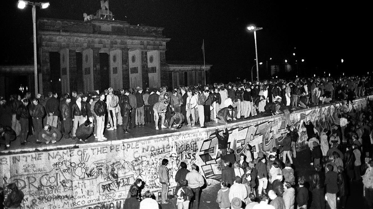 Ciudadanos de Berlín Este y Berlín Oeste celebran sobre el muro el fin de la división de la ciudad, el 9 de noviembre de 1989.