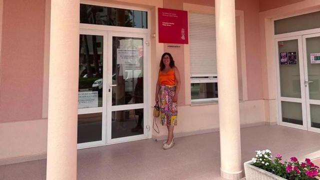 Una dona espera a la porta del consultori mèdic auxiliar de la platja de Xeraco