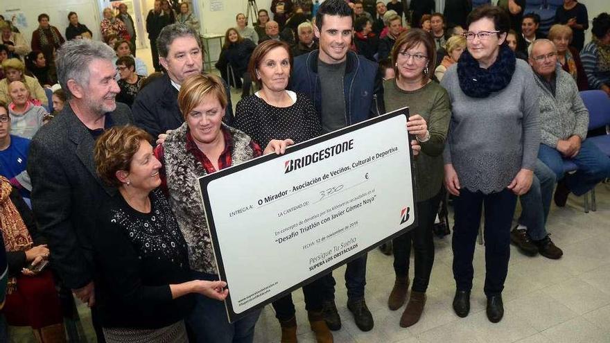 Gómez Noya, haciendo entrega del cheque a la Asociación O Mirador. // Rafa Vázquez