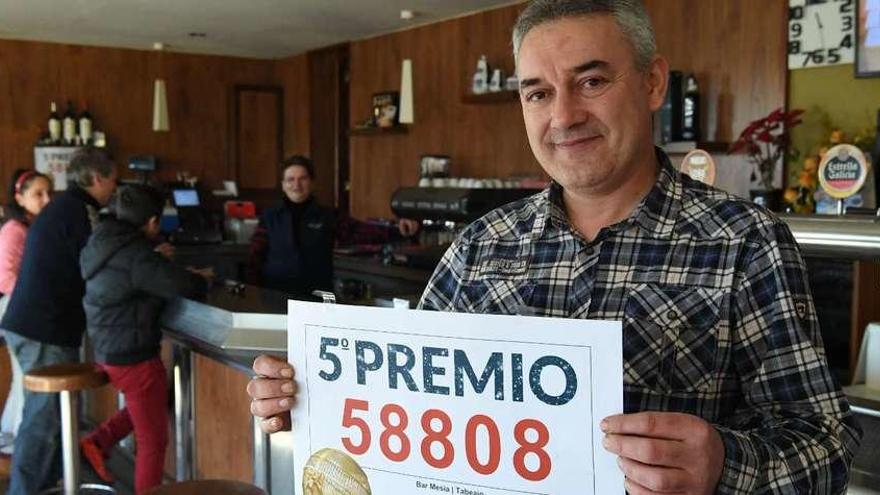 Gonzalo Pablo, responsable del bar Mesía de Carral posa con el número premiado.