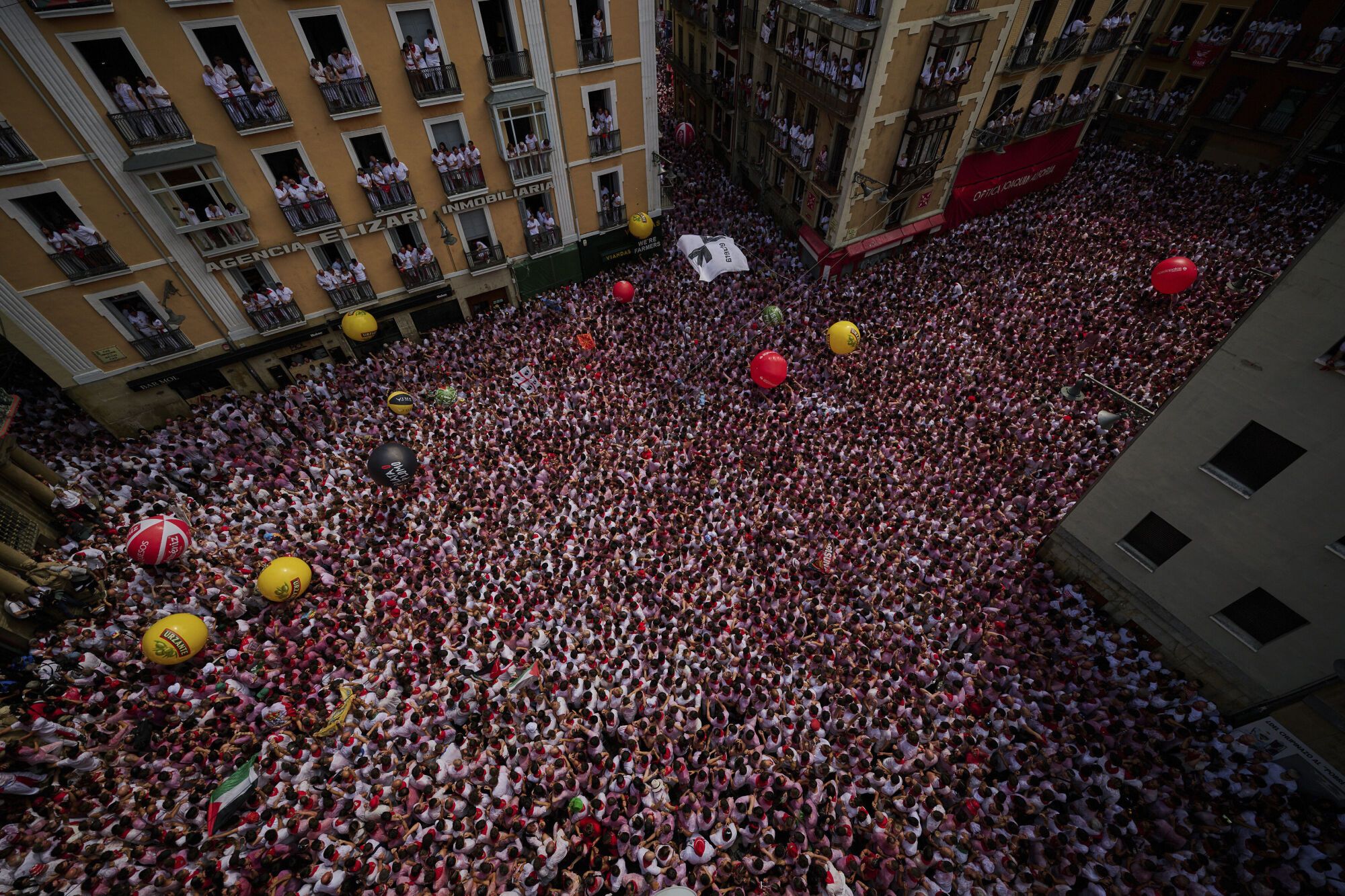 Revelers pack the main square during the start of nine days of uninterrupted partying in Pamplona's famed running-of-the-bulls festival in Pamplona, Spain, Sunday, July 6, 2025. (AP Photo/Miguel Oses). EDITORIAL USE ONLY/ONLY ITALY AND SPAIN