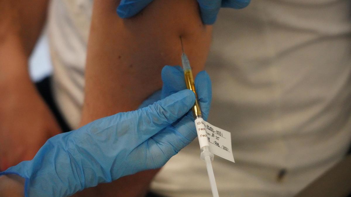 Un sanitario administrando una vacuna.