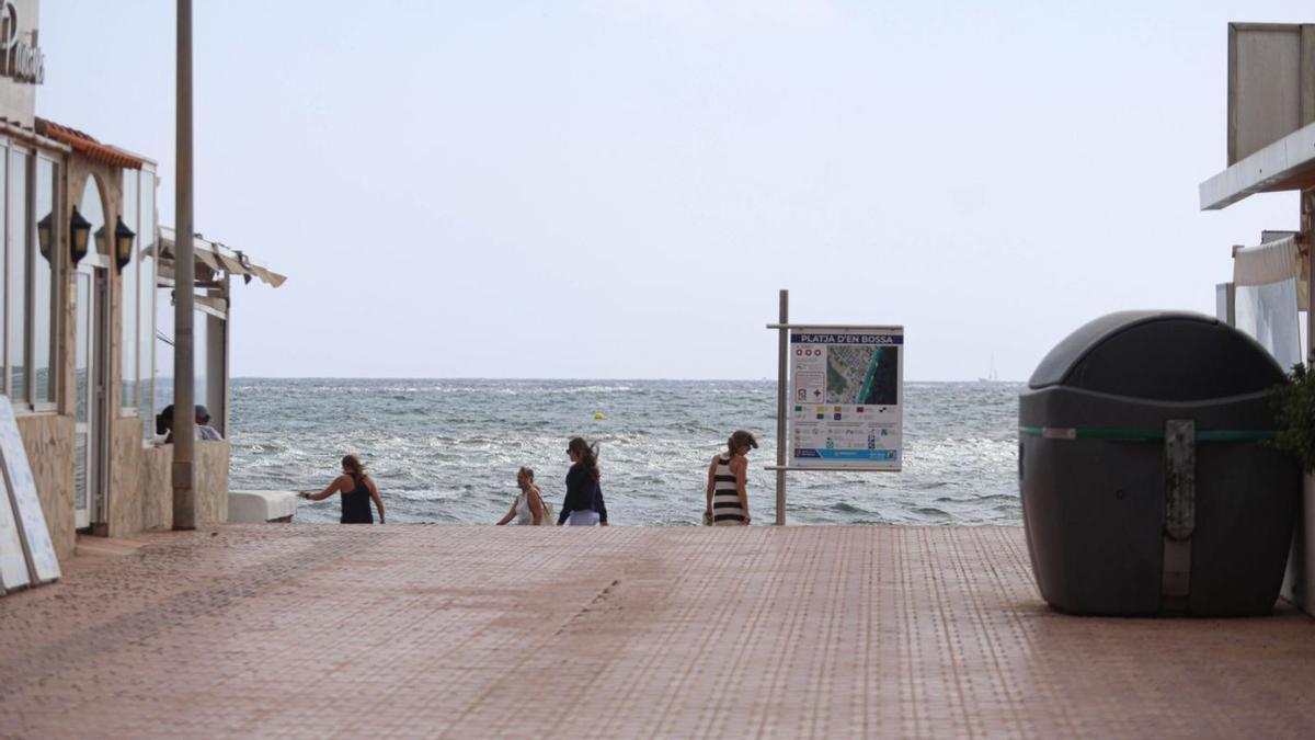 Varias personas, este domingo por la mañana, en Platja d’en Bossa en un día de viento y gris.