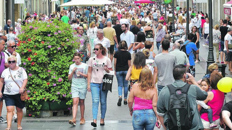 Ciudadanos, de compras y paseo, por la calle Triana.