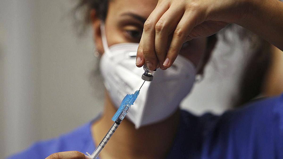 Una mujer sanitaria prepara una vacuna. | I. Buj - E. P.