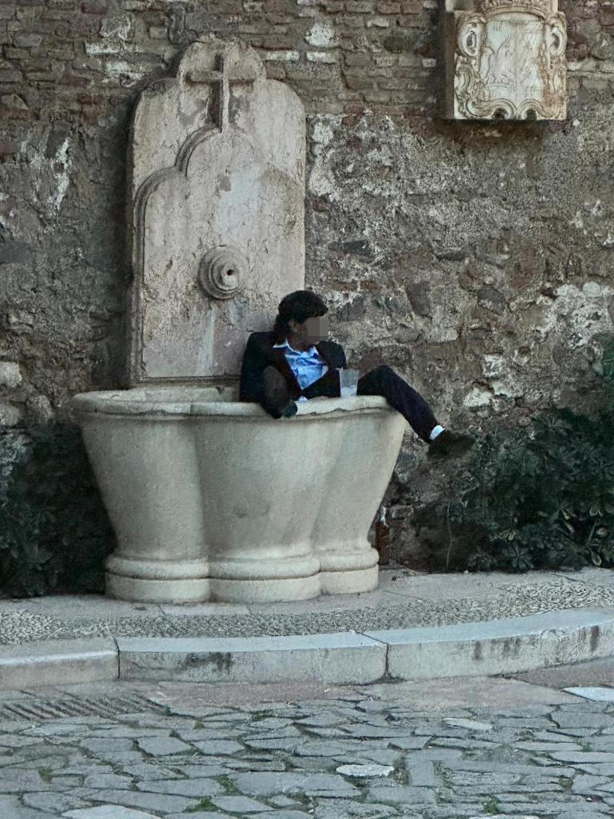 Un individuo descansa en una fuente del XVIII, en el acceso a la Alcazaba.