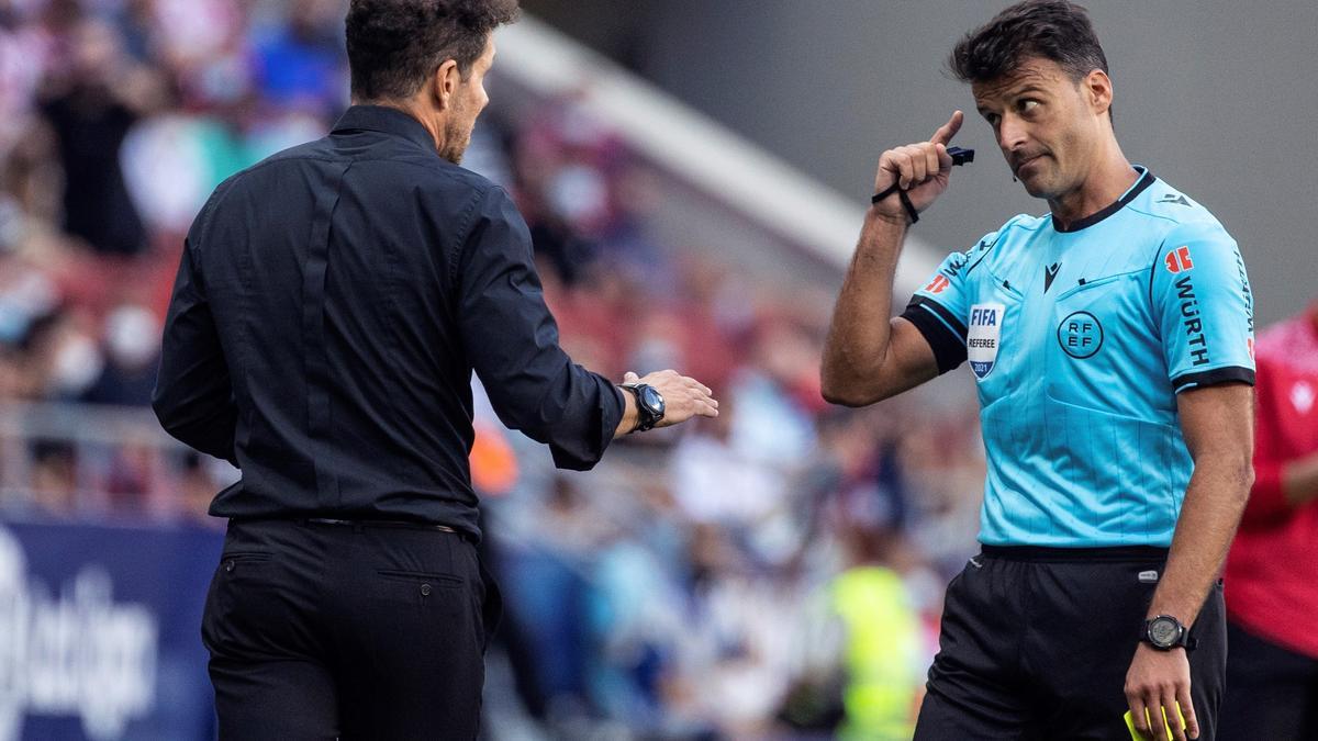 Gil Manzano habla con Simeone durante un partido.