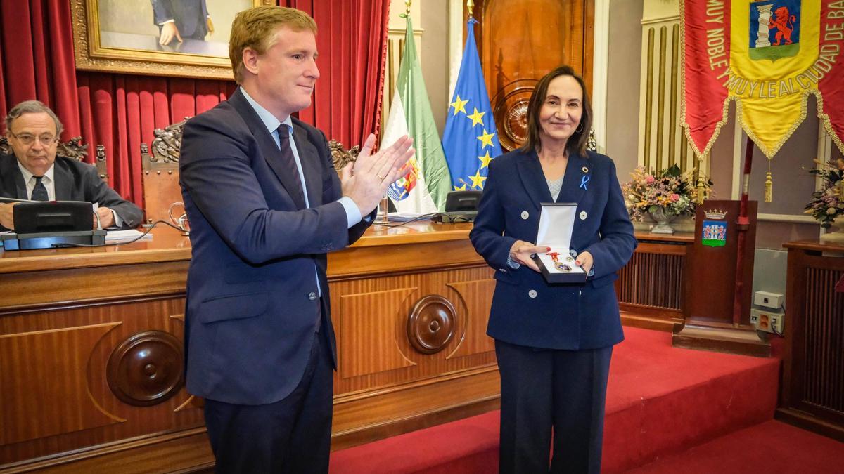 María Jesús Salvatierra recibe de manos del alcalde, Ignacio Gragera, la medalla de concejal.