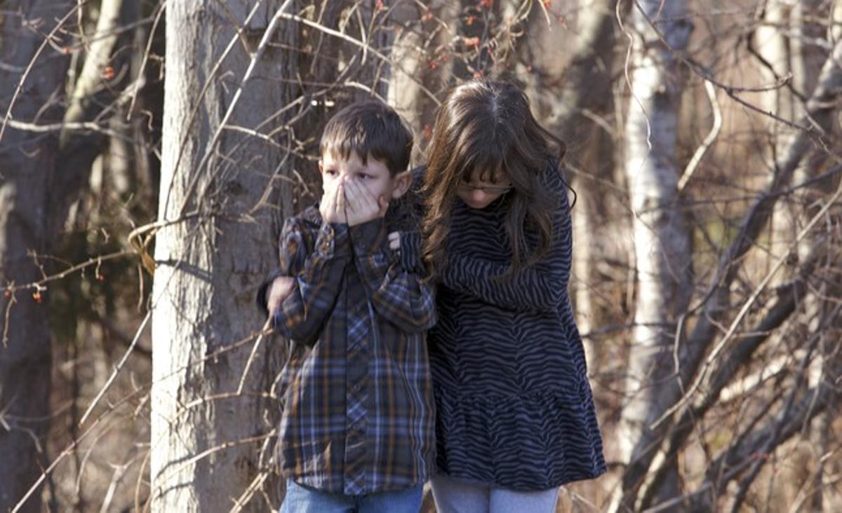 Dos nens del col·legi Sandy Hook de Newtown ploren la mort dels seus amics a mans d’un assassí que va entrar a l’escola i va matar 20 nens de 6 i 7 anys i sis adults.