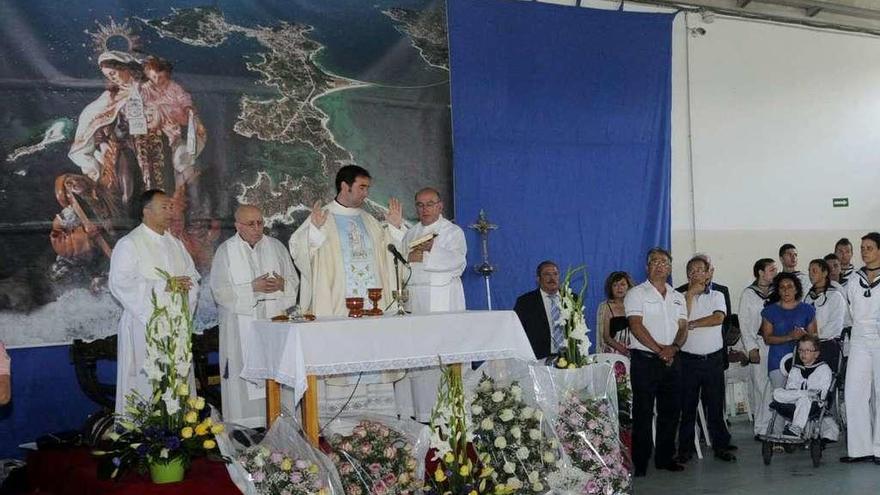 Olimpio Mejuto, segundo por la izquierda, durante una misa dedicada al Carmen en A Illa. // Noé Parga