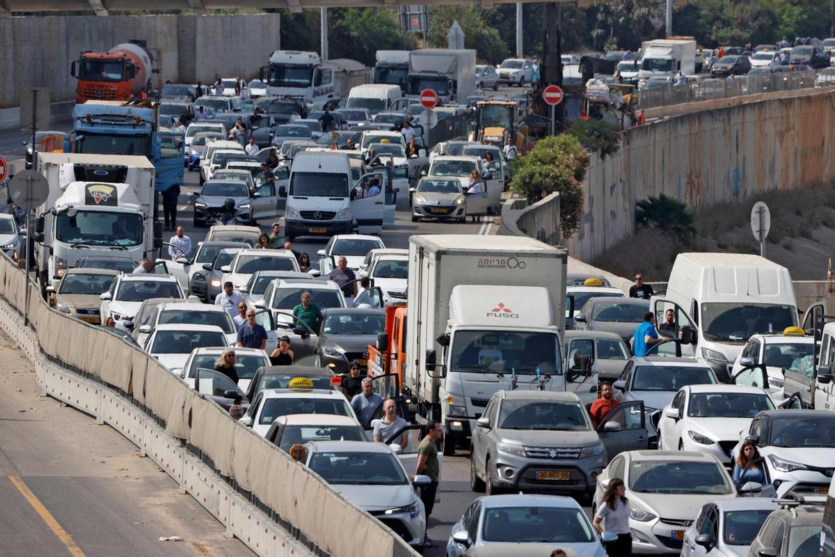 Conductores israelís se detienen y bajan del coche y permanecen en silencio en una carretera de Tel Aviv durante los dos minutos en que han sonado las sirenas en todo el país para recordar a las víctimas del Holocausto.