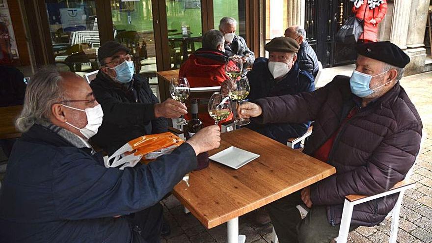 Cuatro amigos brindan por su reencuentro tomando un vino.  | // R.V.