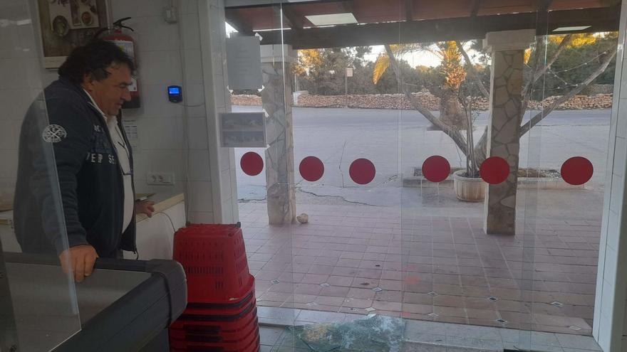 El propietario del supermercado de es Cap observa el destrozo de la puerta de su establecimiento.