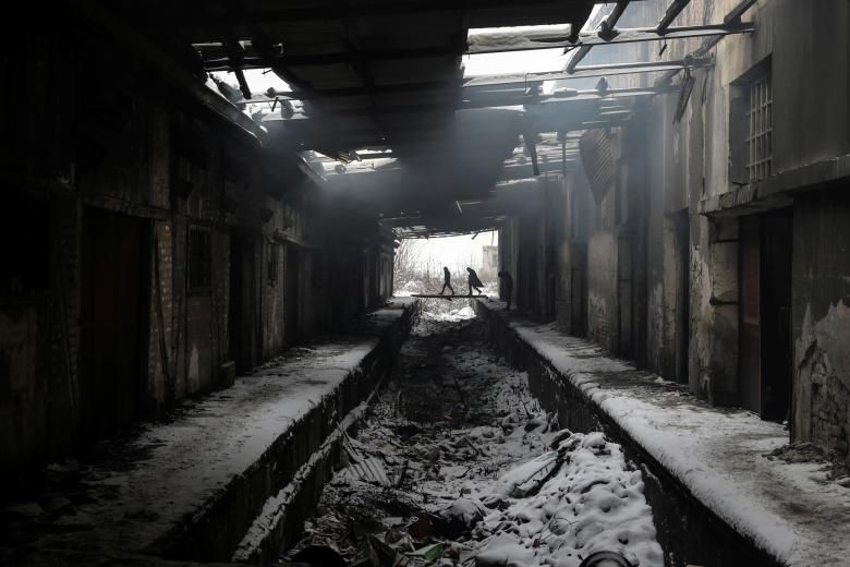 Els migrants caminen durant una nevada a l'interior d'un magatzem duaner abandonat a Belgrad, Sèrbia, l'11 de gener.