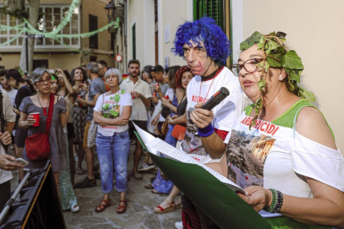 Vecinos de la Calatrava y Canamunt, muchos vestidos de verde y con ramas de árboles, se unen durante sus cercavilas para homenajear a los bellasombras talados en la plaza Llorenç Villalonga.