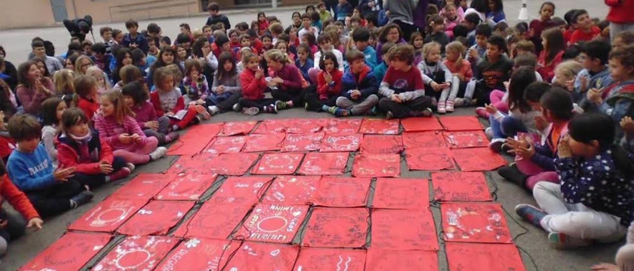 Un grup d&#039;alumnes de primària amb algunes de les motxilles solidàries.