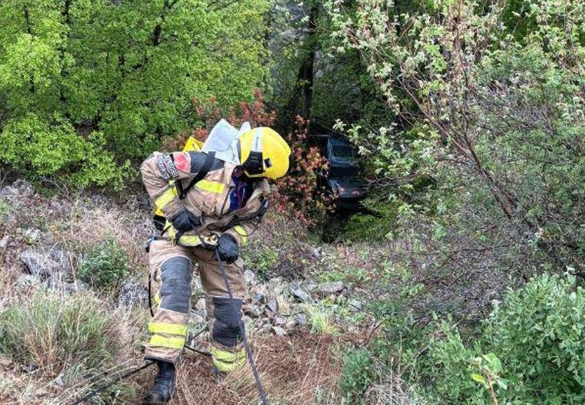 Un bomber accedint al lloc on ha caigut el cotxe