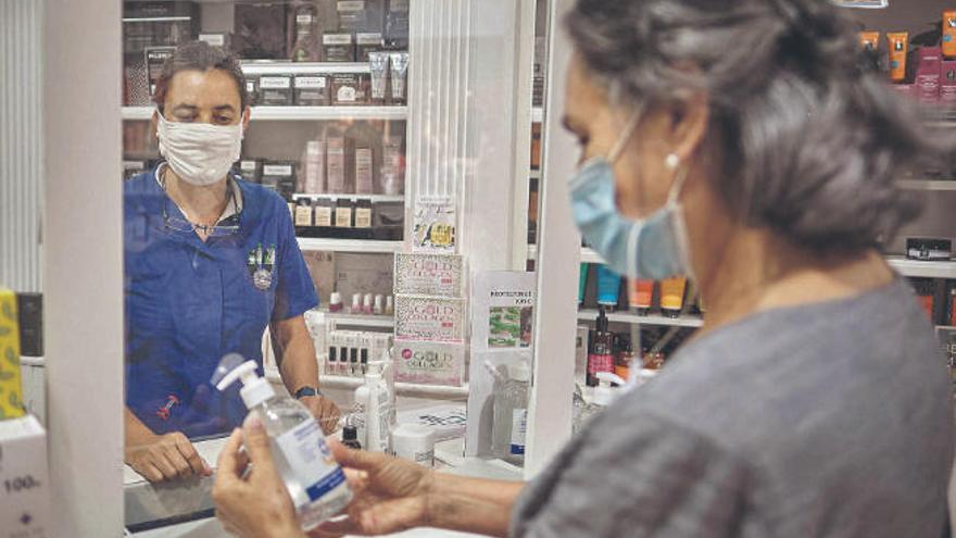 Una mujer compra ayer un gel hidroalcohólico de garantía en una farmacia de Santa Cruz de Tenerife.