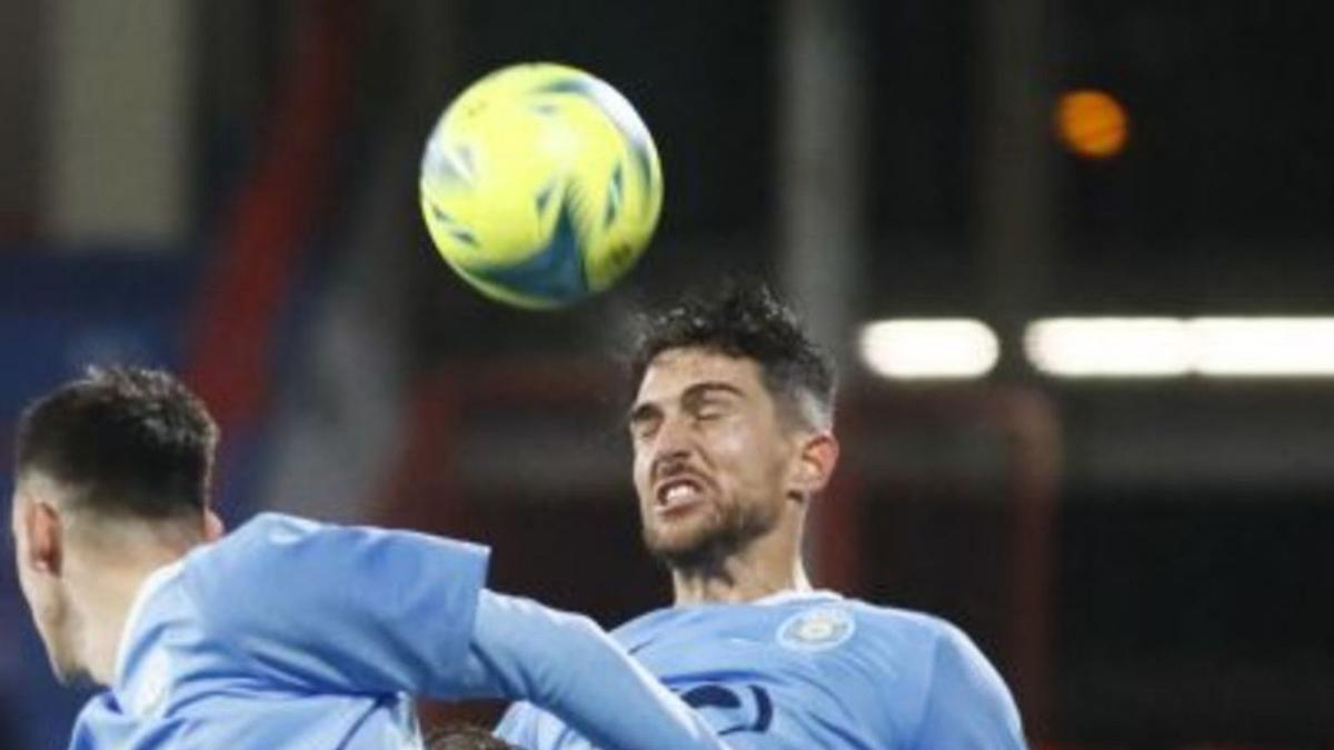 El central Juan ibiza despeja un balón de cabeza.