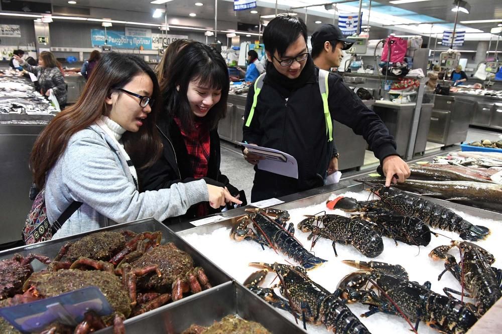 Una treintena de alumnos del Centro de Linguas de la Universidad coruñesa procedentes de China y Vietnam visitan el mercado de la plaza de Lugo para aprender argot gastrónomico gallego.