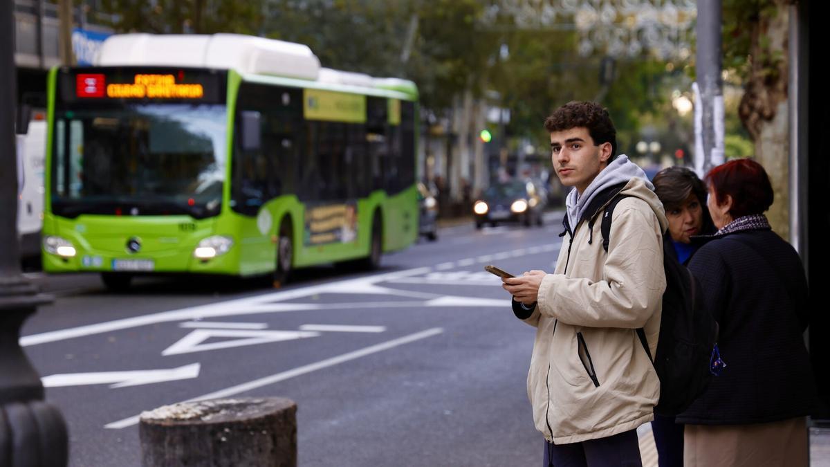 Usuarios esperan la llegada del autobús en una parada, en una imagen de archivo.