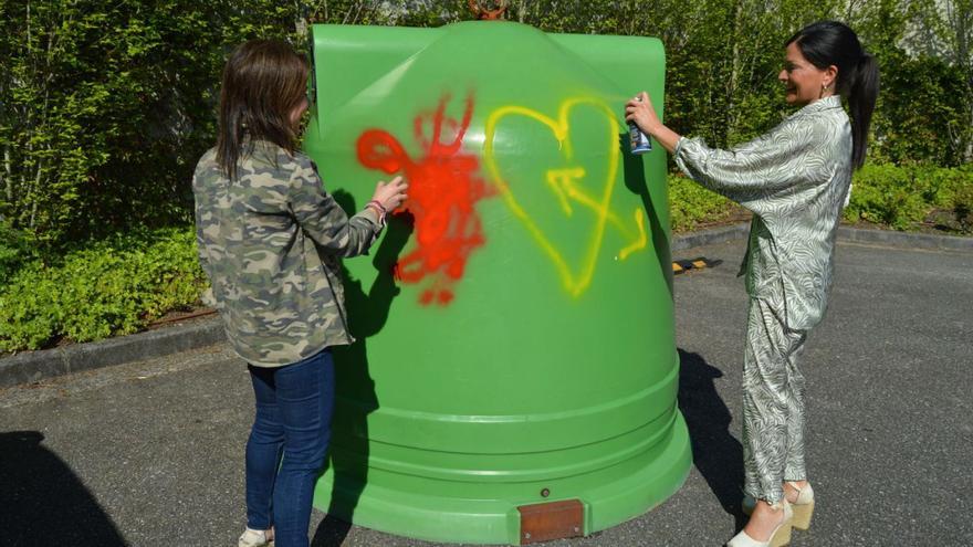 La edil de Medio Ambiente, Laura Méndez, y la alcaldesa, Nidia Arévalo, pintan grafitis en un iglú. |   // D.P.