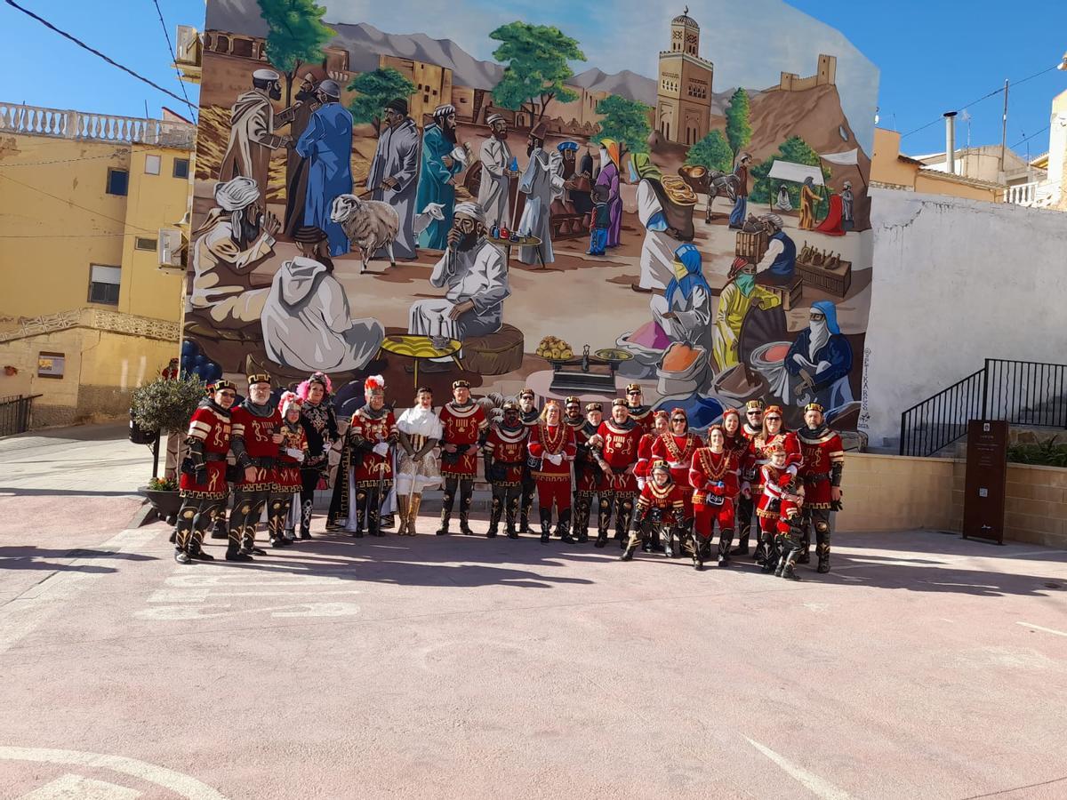 Festeros de la comparsa de Alagoneses en el mural de la plaza Biólogo Fernando Maestre Gil.