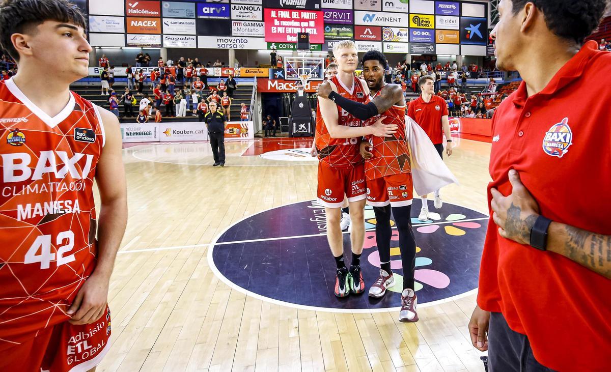 Jugadors del Baxi celebren una victòria al centre de la pista, sobre el logotip de Kids&amp;Us